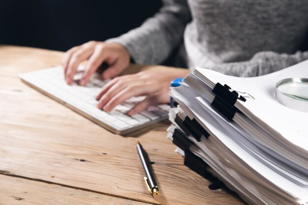 Woman working on computer with documents