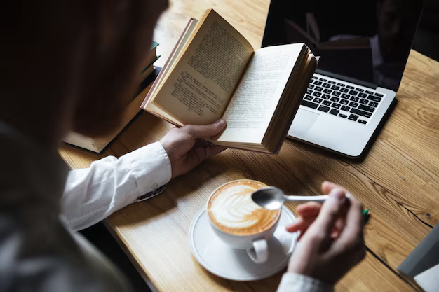 Top view of man with coffee reading book